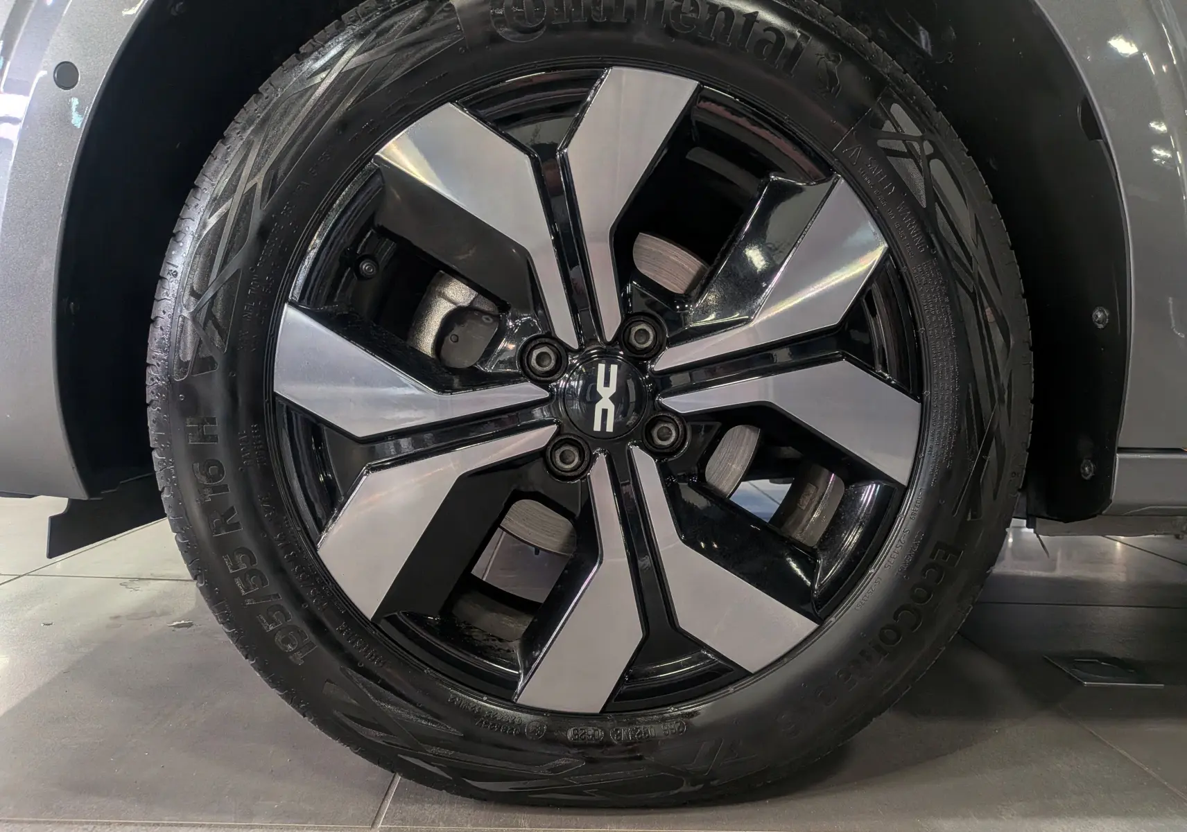 Gros plan sur la jante alliage bicolore noire et argentée du côté avant droit de la Dacia Sandero gris schiste 2025.