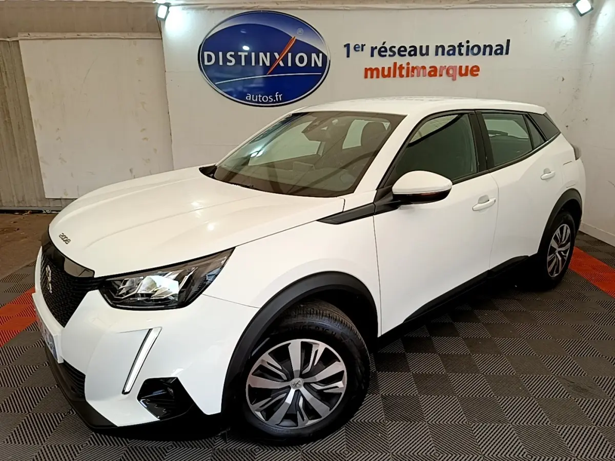 Peugeot 2008 blanc vue 3/4 avant droit dans un showroom avec jantes alliage et feux LED distinctifs.
