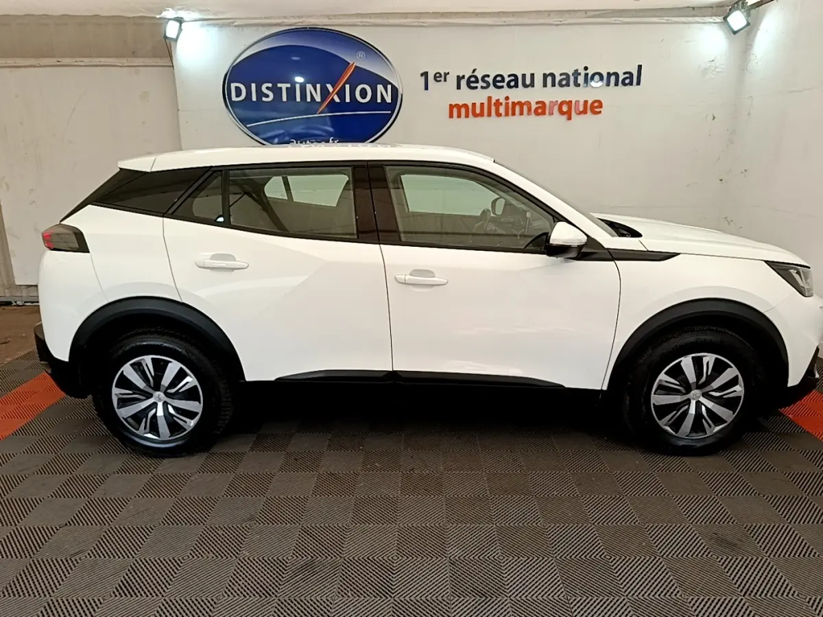 Profil côté gauche du SUV Peugeot 2008 blanc 2021 avec jantes alliage et détails noirs contrastants.