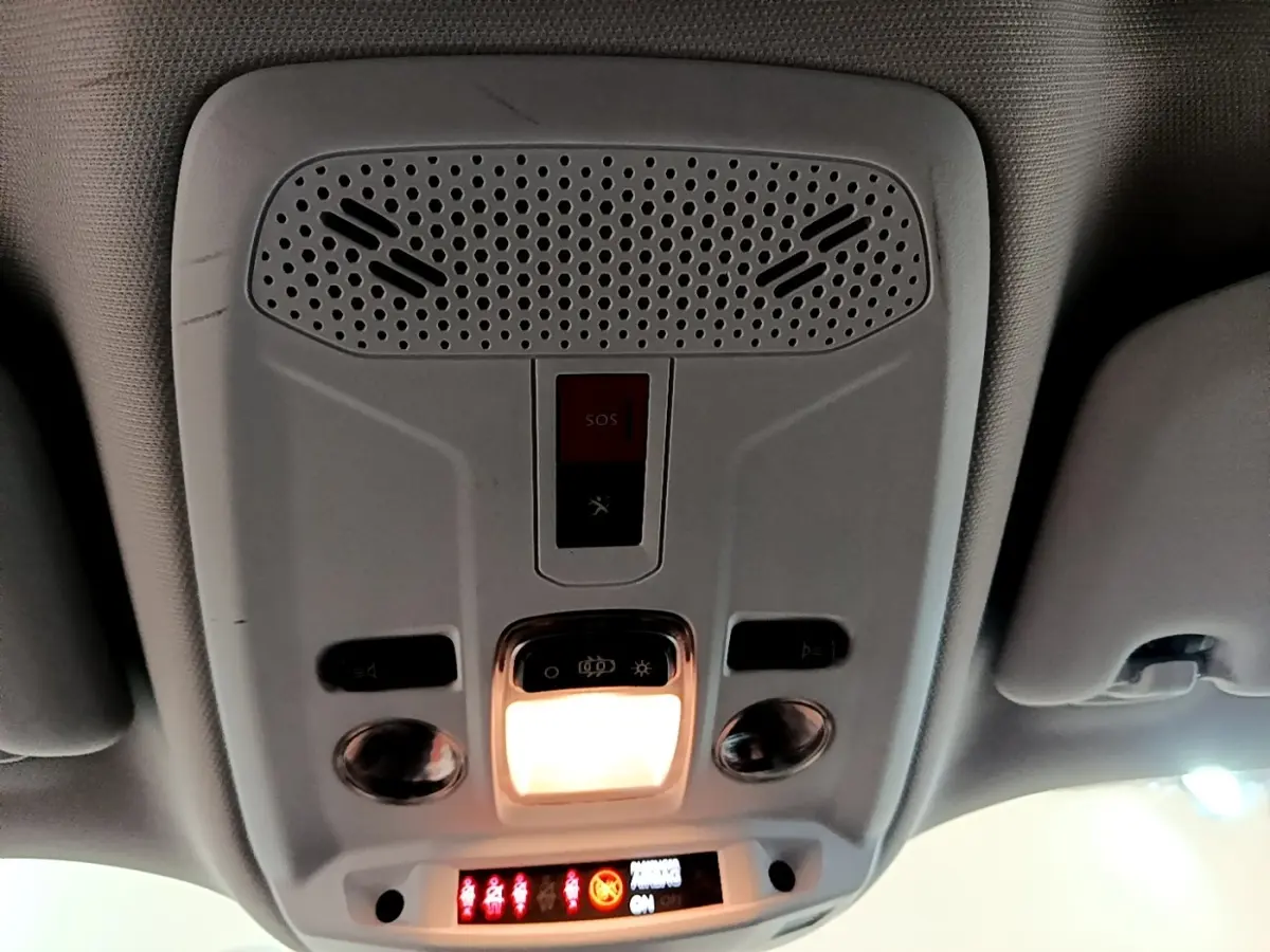 Vue intérieure du plafonnier avec éclairage et bouton SOS du Peugeot 2008 blanc, version BlueHDi 110 S&S Active Business.