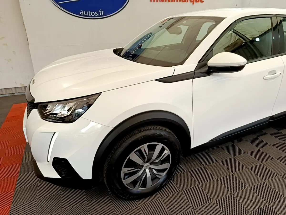 Vue 3/4 avant droit d’un Peugeot 2008 blanc avec phares LED et jantes alliage distinctives.