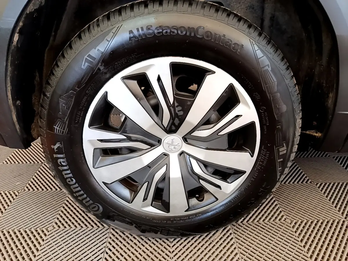Gros plan sur la roue avant droite d'un Peugeot 2008 blanc, avec jante alliage et pneu Continental AllSeasonContact.