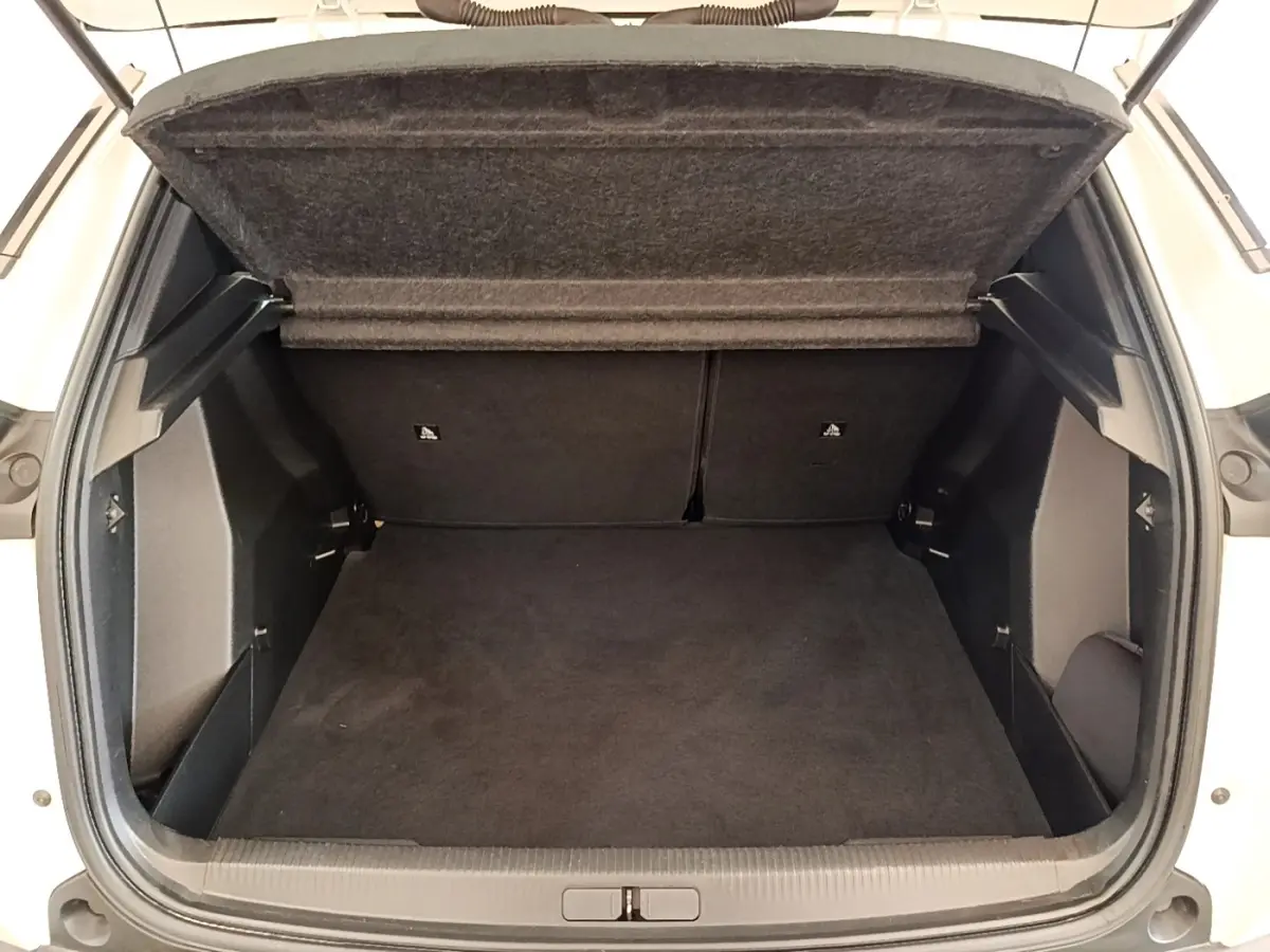 Coffre ouvert vu de face d’un Peugeot 2008 blanc, montrant un espace de chargement propre et spacieux.