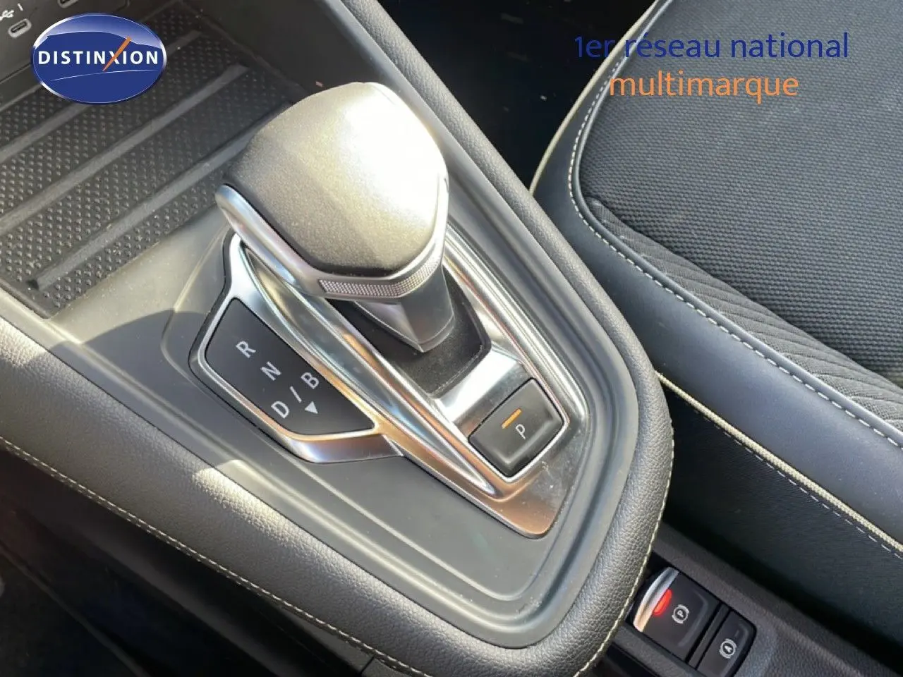 Gros plan sur la console centrale de la Renault Symbioz 2025, levier de vitesses automatique et sellerie tissu noir.