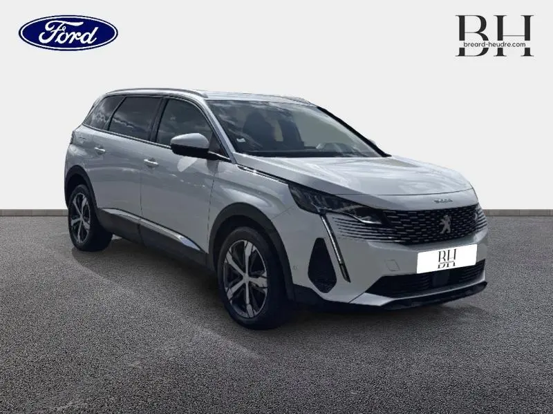 Peugeot 5008 blanc nacré vue 3/4 avant droit, calandre noire et jantes alliage distinctives.