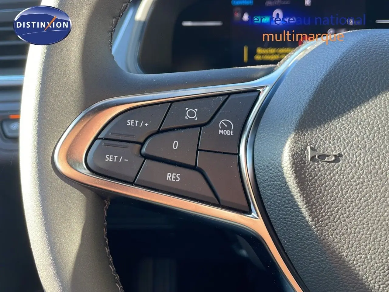 Gros plan sur les commandes au volant côté gauche du Renault Captur E-Tech gris rafale, avec finition chrome et cuir noir.