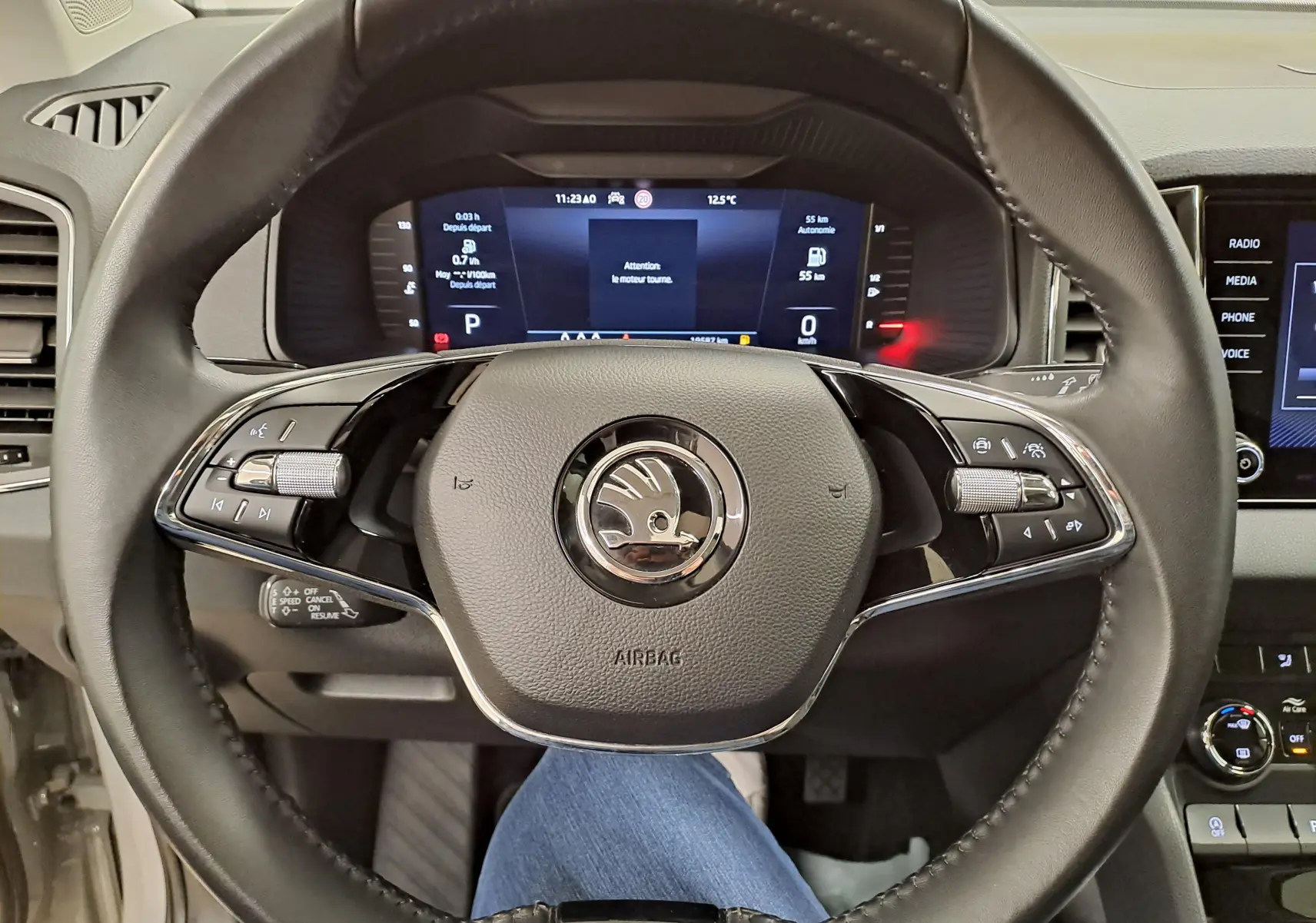 Vue rapprochée du volant noir du Skoda Karoq 2023 avec tableau de bord digital et commandes intégrées.
