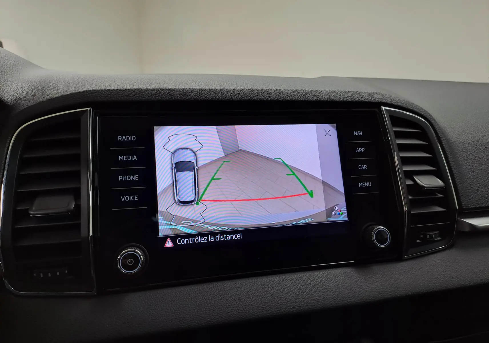 Écran central du Skoda Karoq 2023 affichant la caméra de recul avec guidage et alertes de distance.