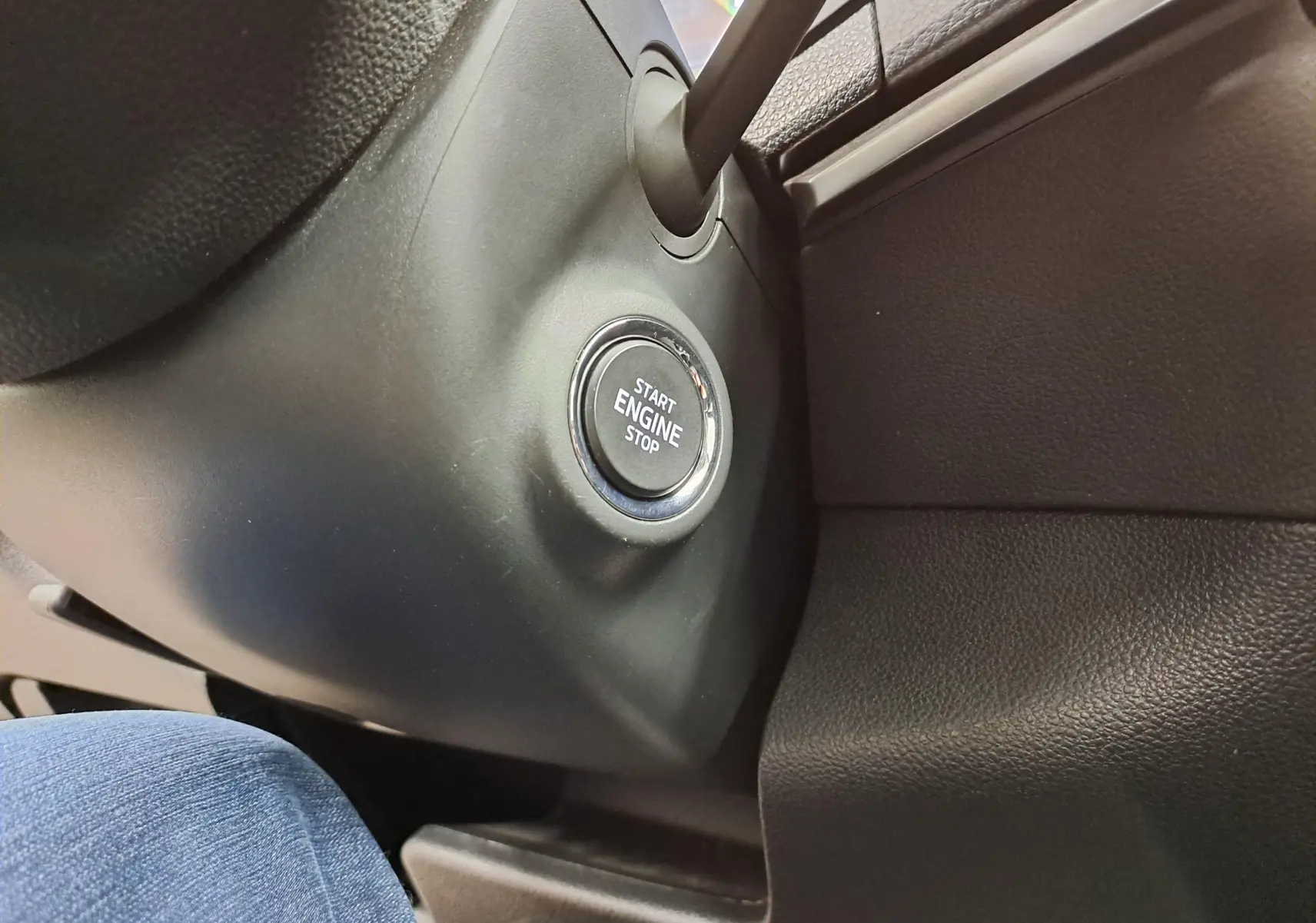 Bouton start/stop moteur en gros plan sur la console noire intérieure du Skoda Karoq gris perle 2023.