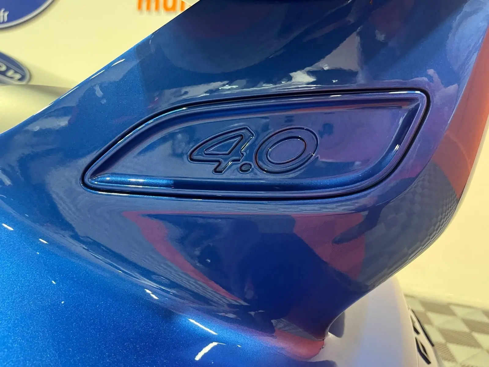 Gros plan sur l’inscription 4.0 en relief sur l’aile arrière bleu saphir de la Porsche 911 GT3.