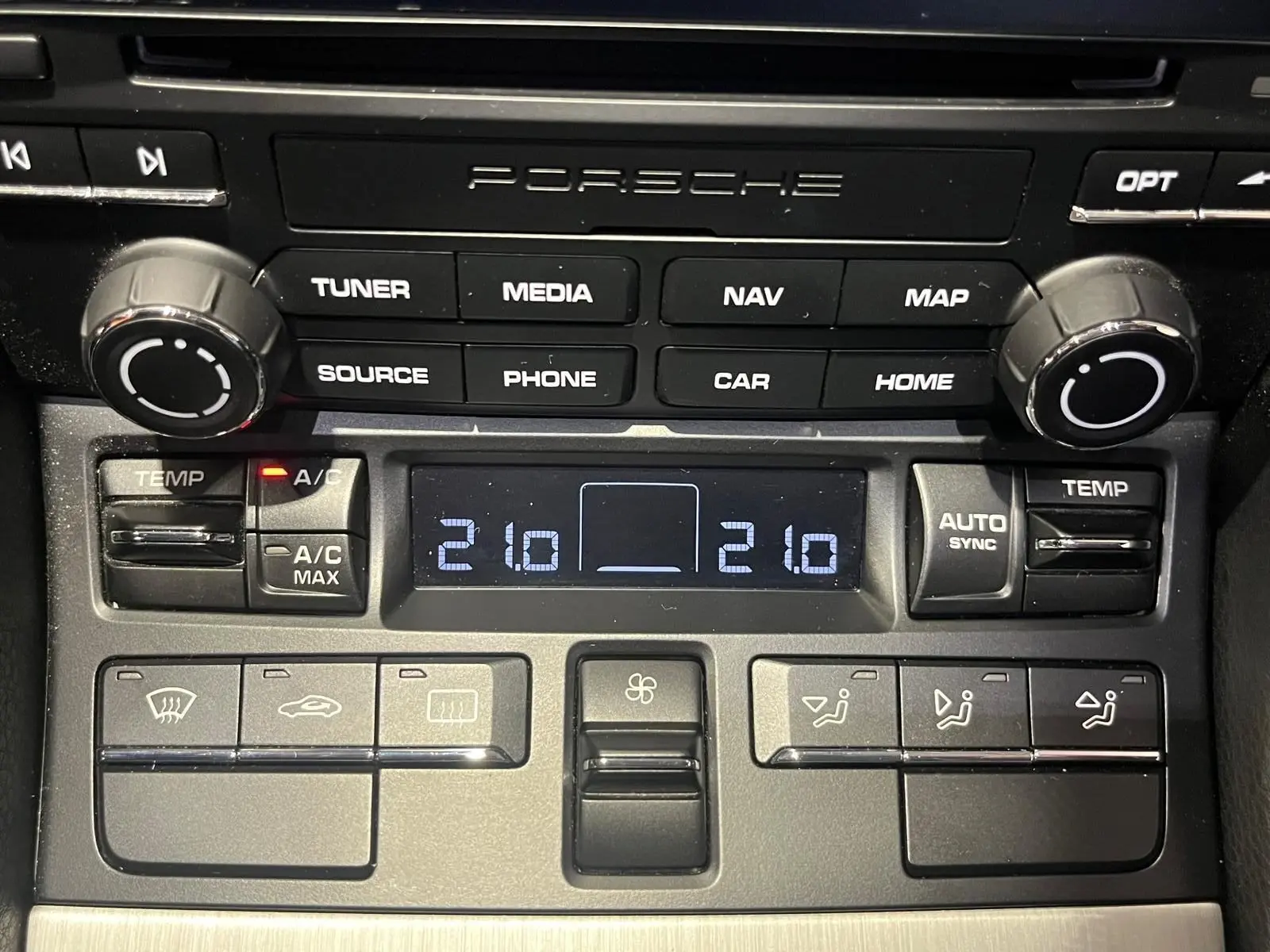 Tableau de bord Porsche 911 GT3 2018, zoom sur commandes climatisation et système audio noir mat.