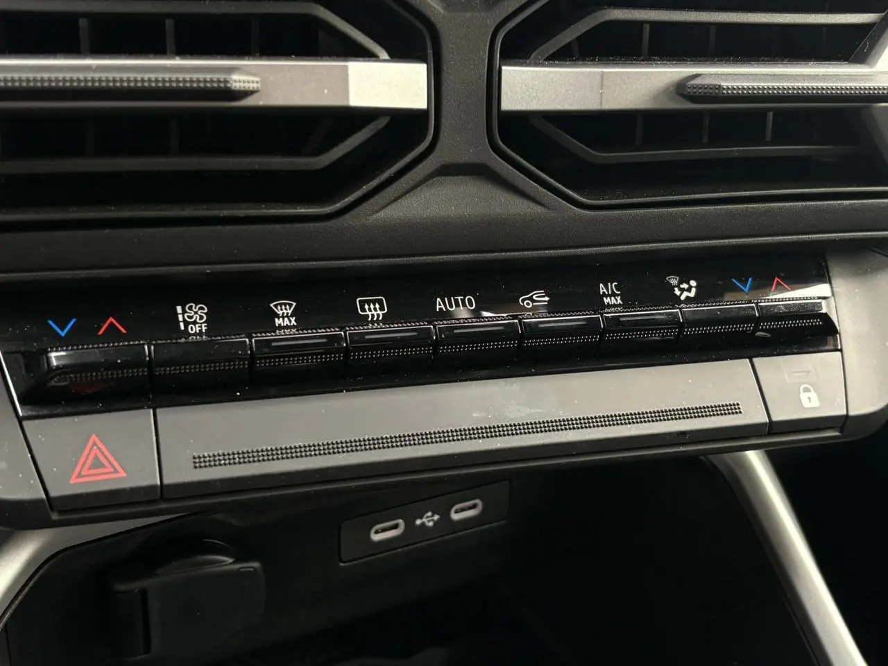 Vue rapprochée de la console centrale du Dacia Bigster blanc, montrant les commandes de climatisation et ports USB.
