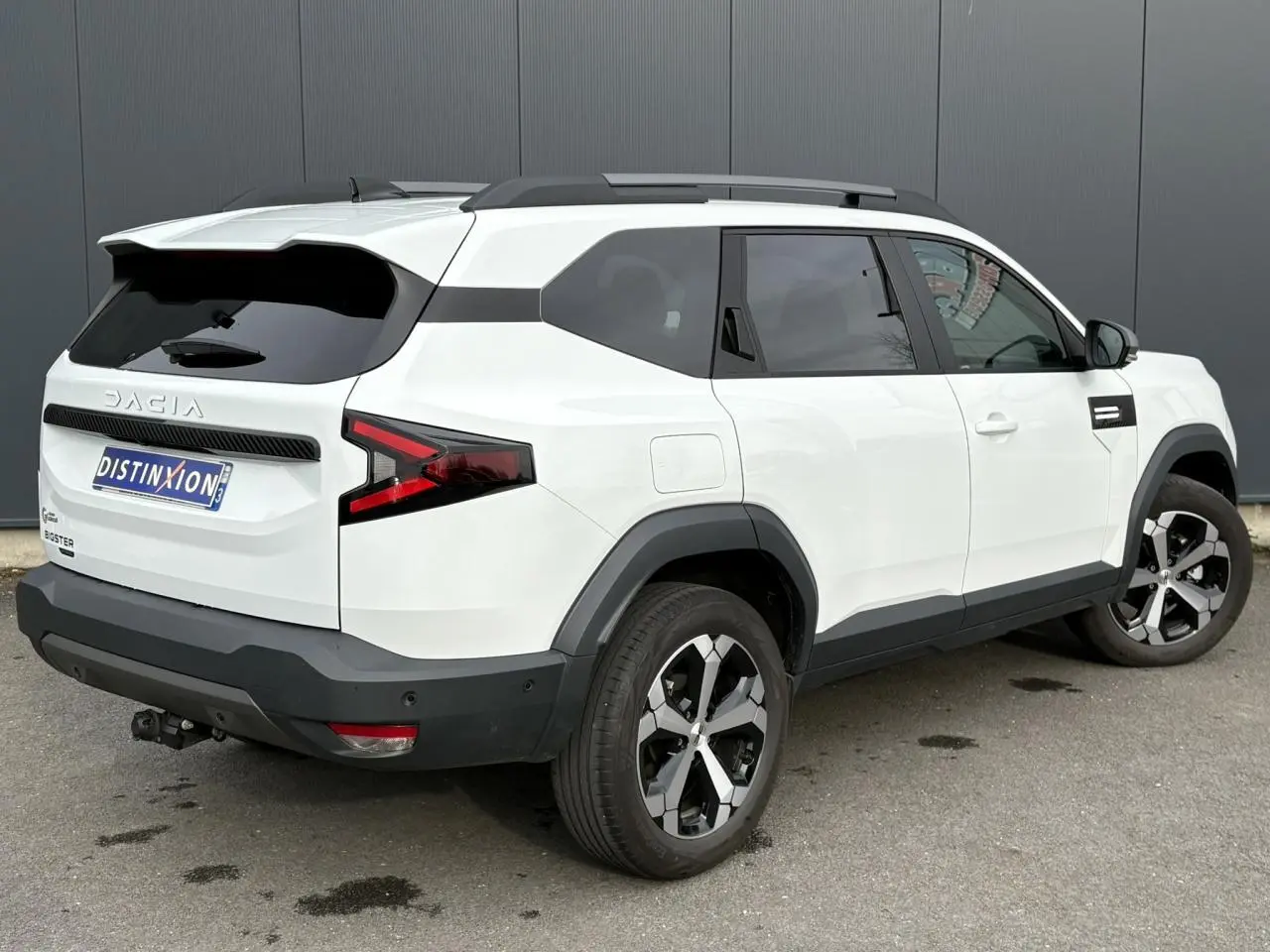Vue 3/4 arrière droite du Dacia Bigster blanc Banquise avec attelage démontable et jantes alliage 18 pouces.