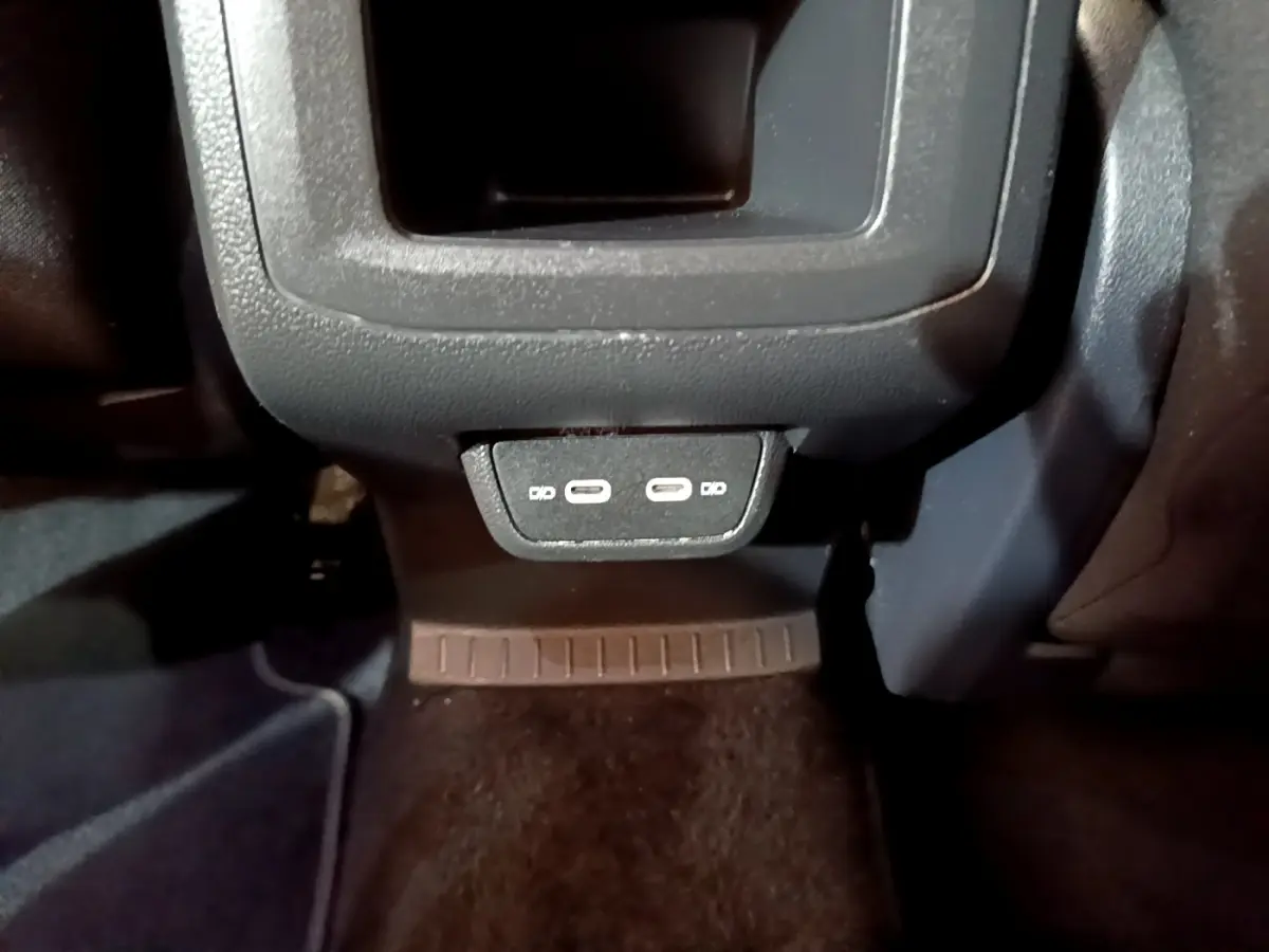 Vue rapprochée des ports USB-C arrière noirs du Volkswagen T-Cross 2022, côté passager, avec moquette sombre.