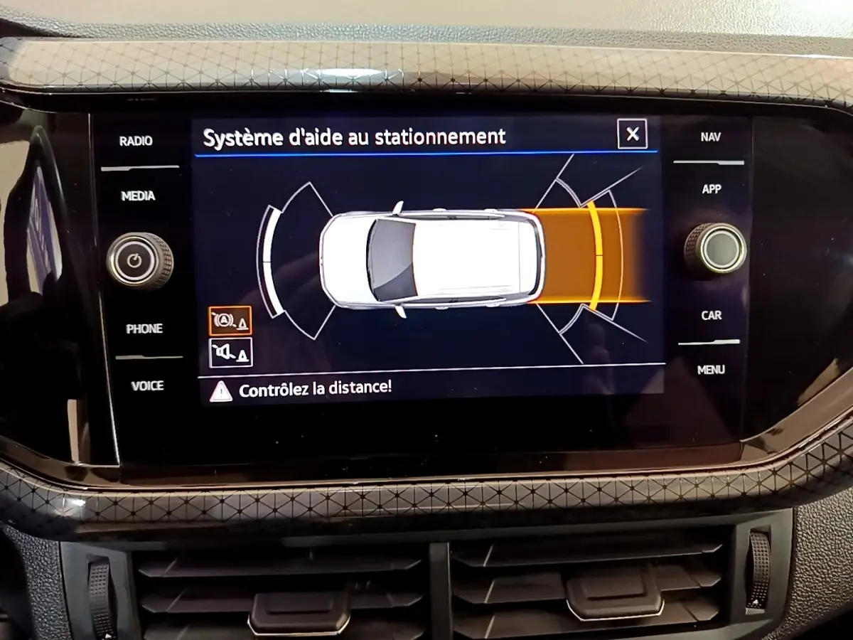Écran tactile intérieur du Volkswagen T-Cross noir 2022 montrant le système d'aide au stationnement.