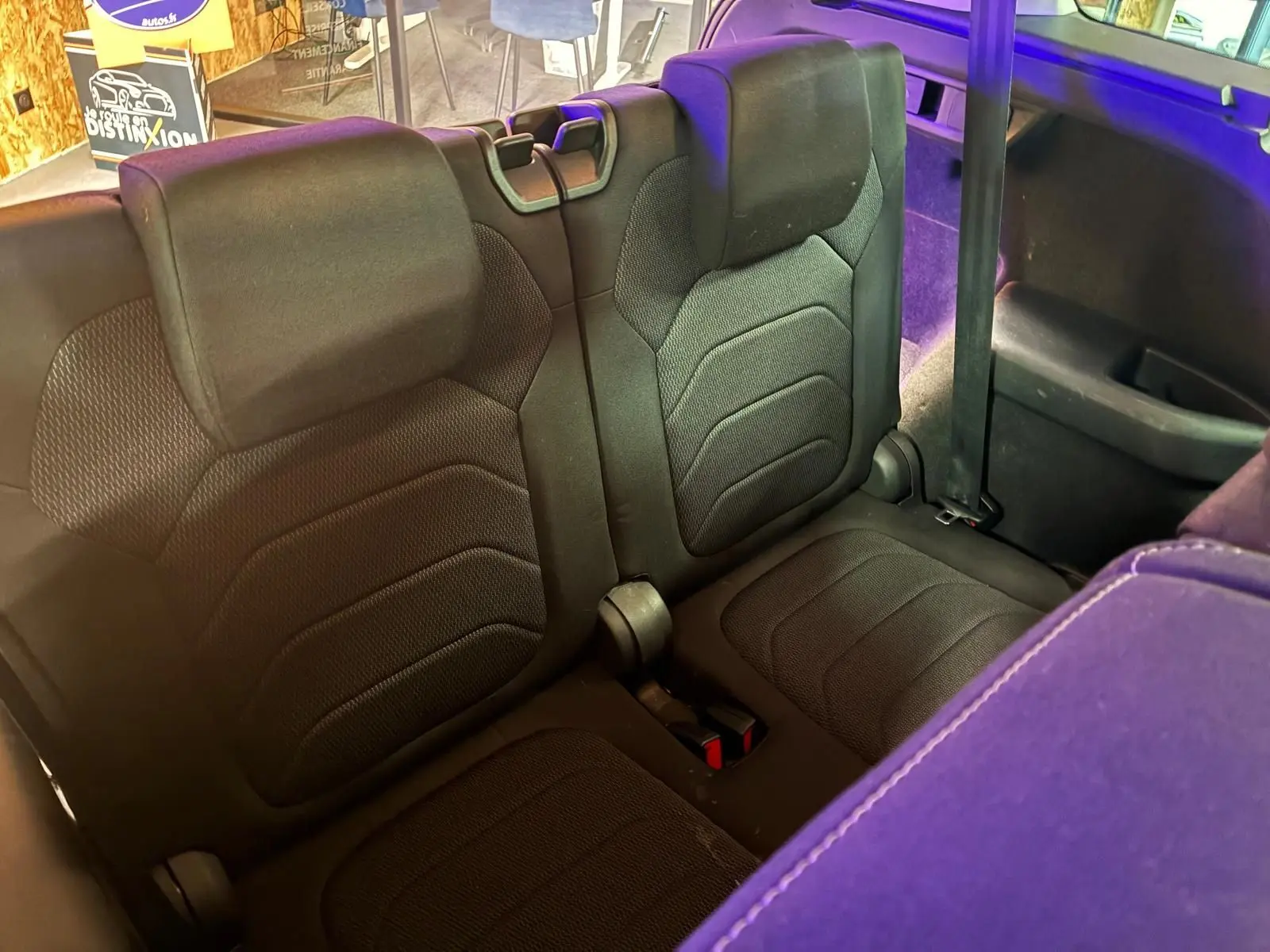 Vue rapprochée des sièges arrière en tissu noir du Skoda Kodiaq 2023, avec ceinture de sécurité visible côté droit.