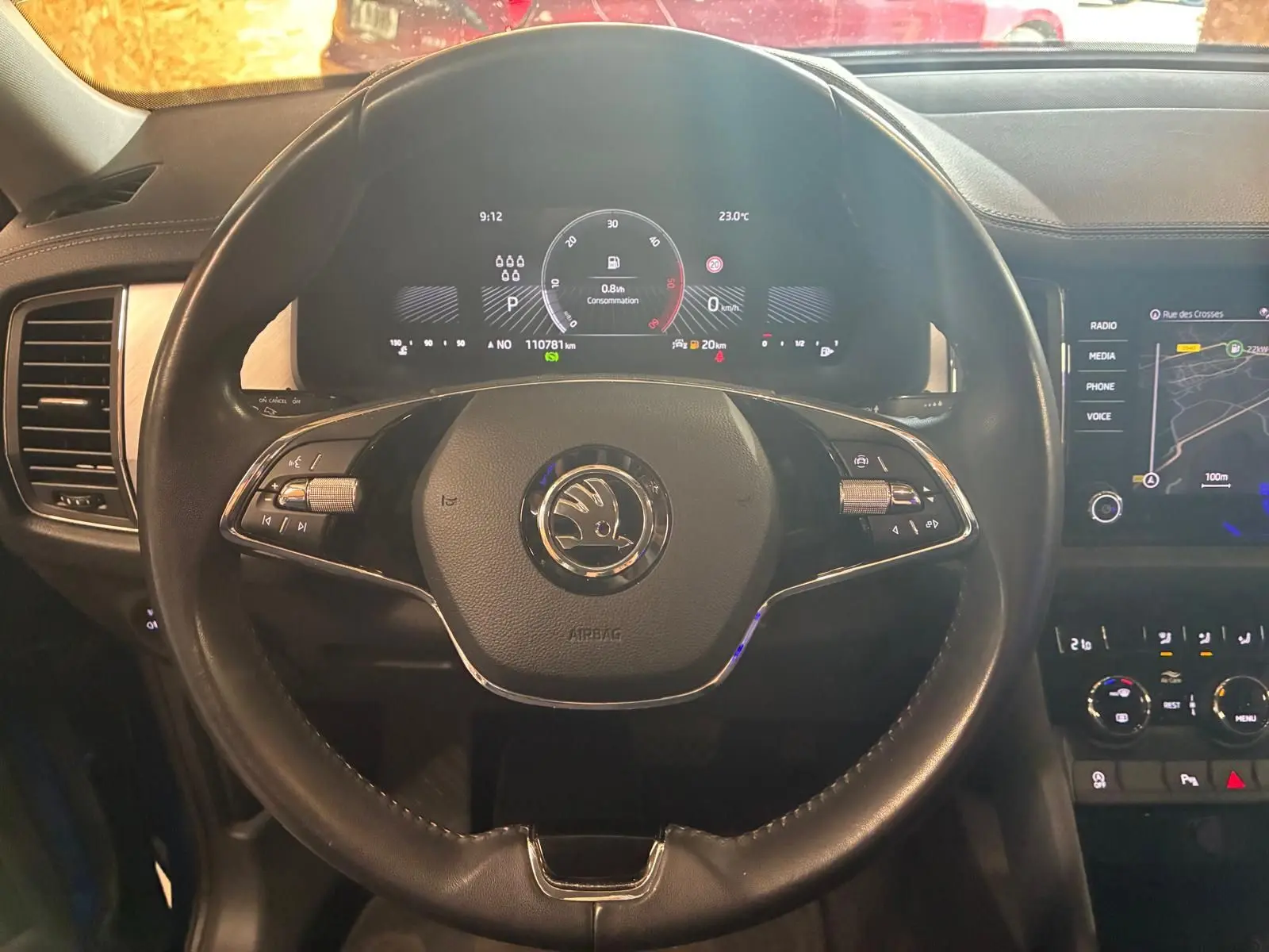 Vue intérieure centrée sur le volant noir du Skoda Kodiaq 2023 avec tableau de bord digital et écran tactile GPS.