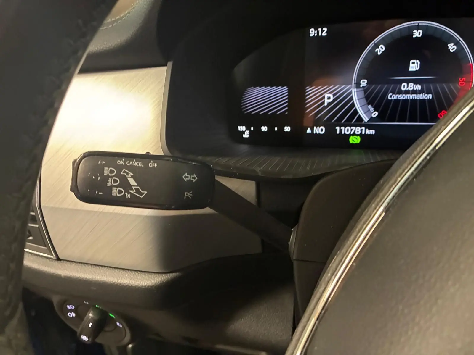 Gros plan sur le compteur et la commande de clignotant à gauche dans l’habitacle d’un Skoda Kodiaq bleu 2023.