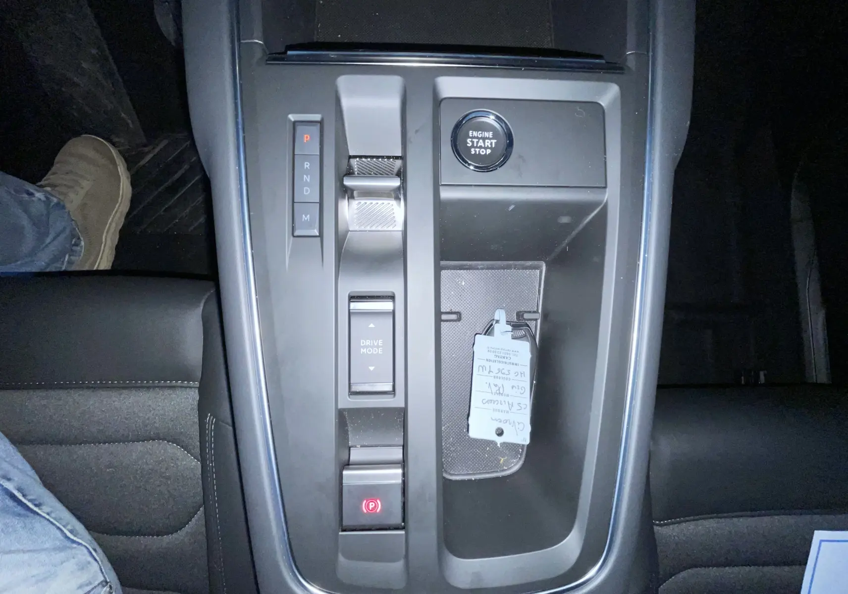Vue plongeante sur la console centrale noire du Citroën C5 Aircross hybride 2025 avec bouton start et sélecteur de mode de conduite.