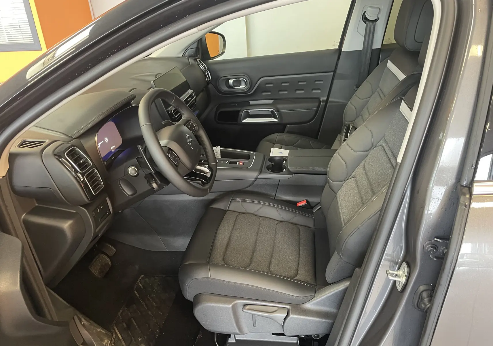 Vue intérieure côté conducteur du Citroën C5 Aircross gris platinium 2025, sièges tissu/TEP et volant cuir.