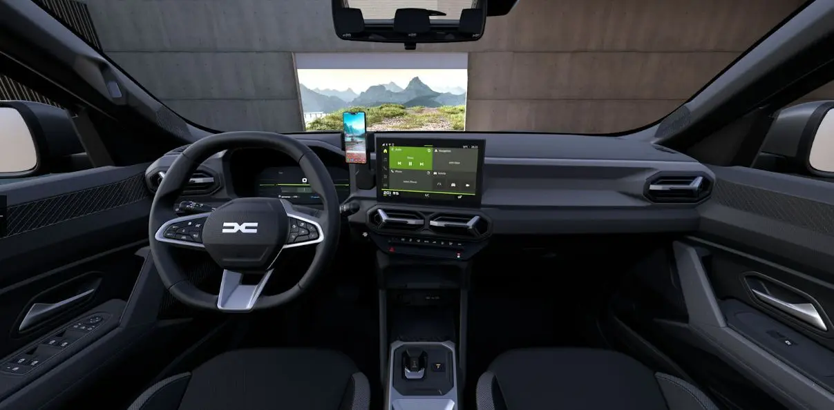 Vue intérieure frontale du tableau de bord du Dacia Duster 2026, avec écran tactile central et volant multifonction.