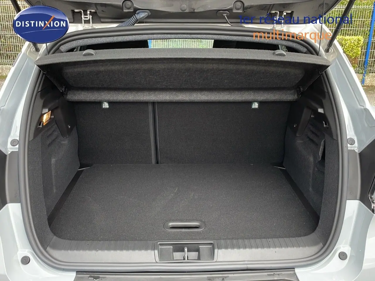 Coffre ouvert du Renault Captur E-Tech gris Rafale avec toit beige, vue arrière montrant l'espace de chargement vide.