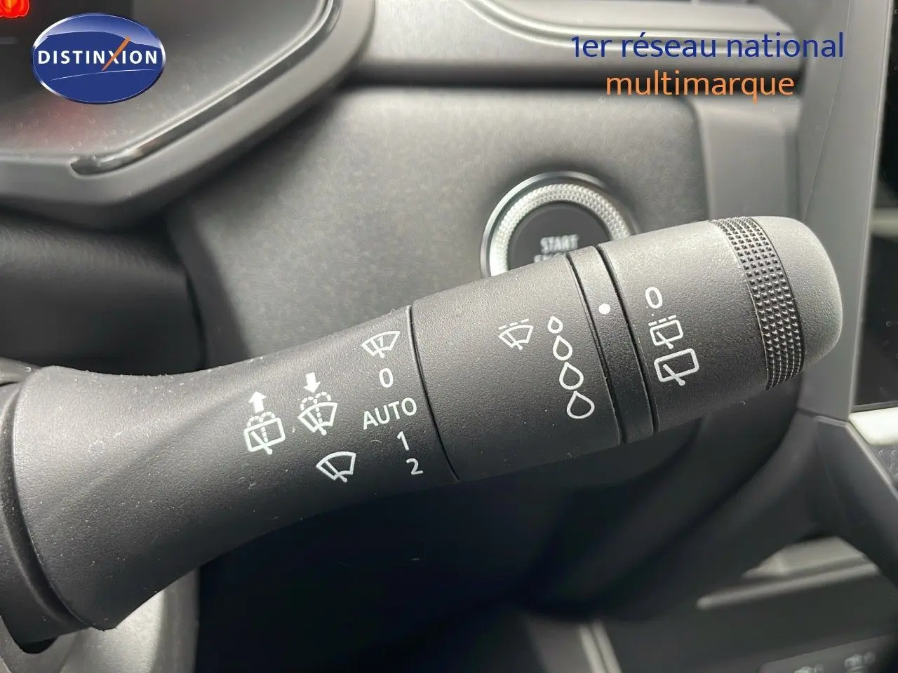 Gros plan sur la commande d'essuie-glace du Renault Captur E-Tech gris rafale avec bouton start visible en arrière-plan.