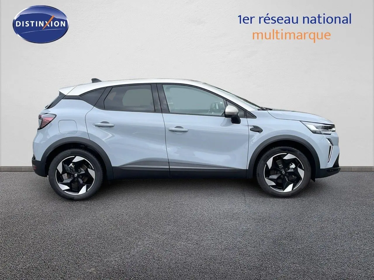 Profil droit d'un Renault Captur 2025 hybride gris rafale avec toit beige et jantes noires bicolores.