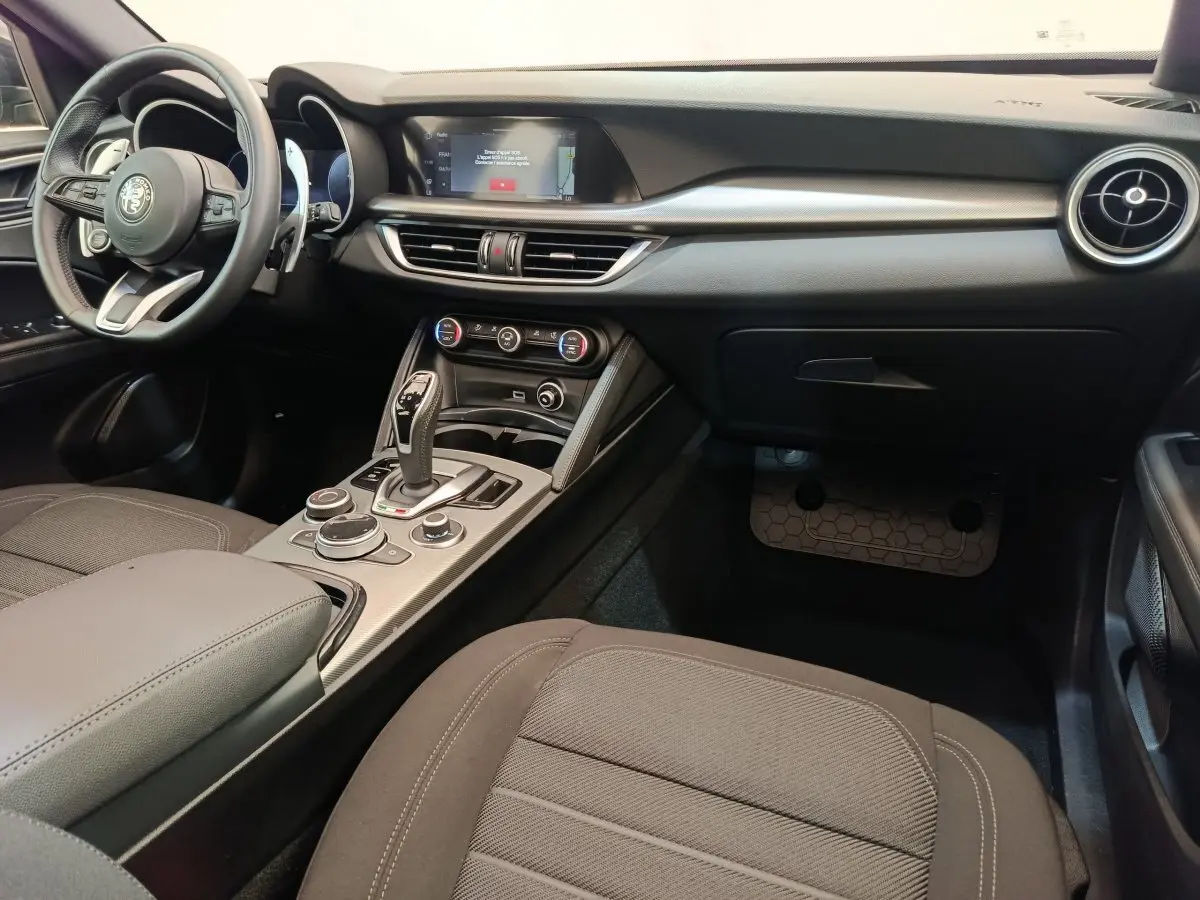 Intérieur de l'Alfa Romeo Stelvio 2.2 TD Sprint 2024, vue côté passager, tableau de bord et console centrale noirs.