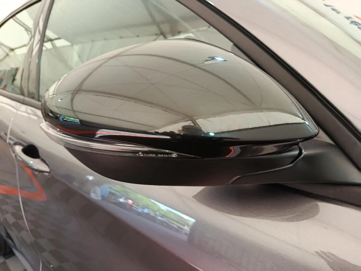 Rétroviseur côté droit gris foncé de l'Alfa Romeo Stelvio 2024 avec clignotant intégré, vue rapprochée.