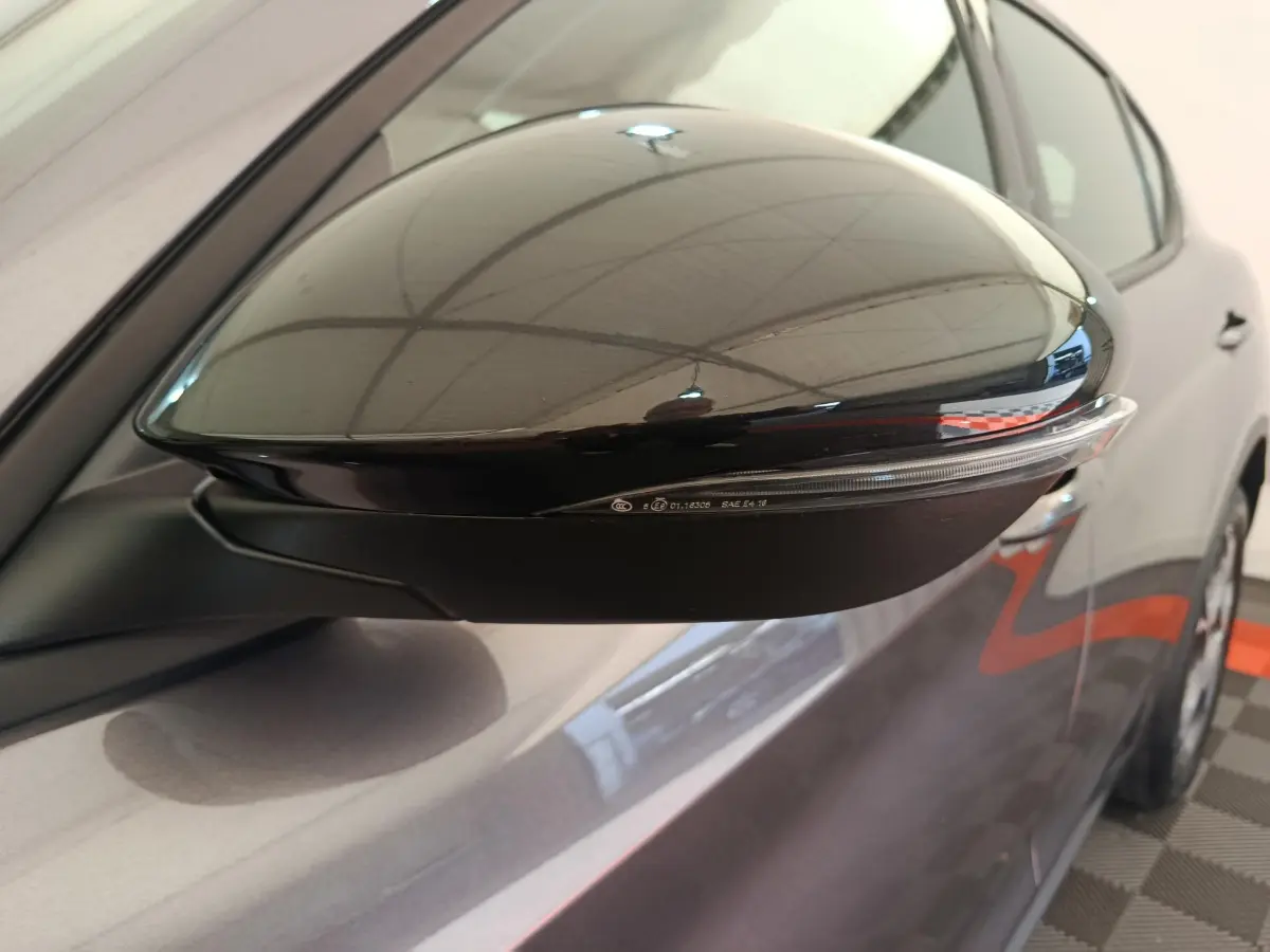 Rétroviseur côté droit noir brillant sur Alfa Romeo Stelvio gris foncé, vue rapprochée du côté avant.