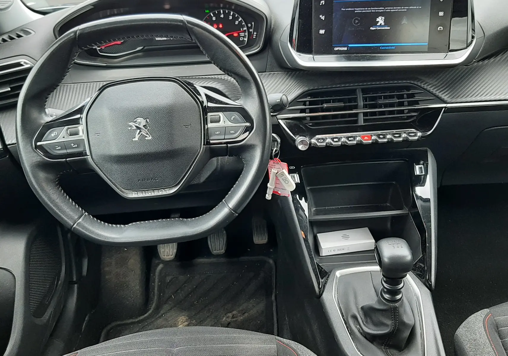 Vue intérieure du tableau de bord du Peugeot 2008 2020, volant compact, écran tactile central et levier de vitesses manuel.