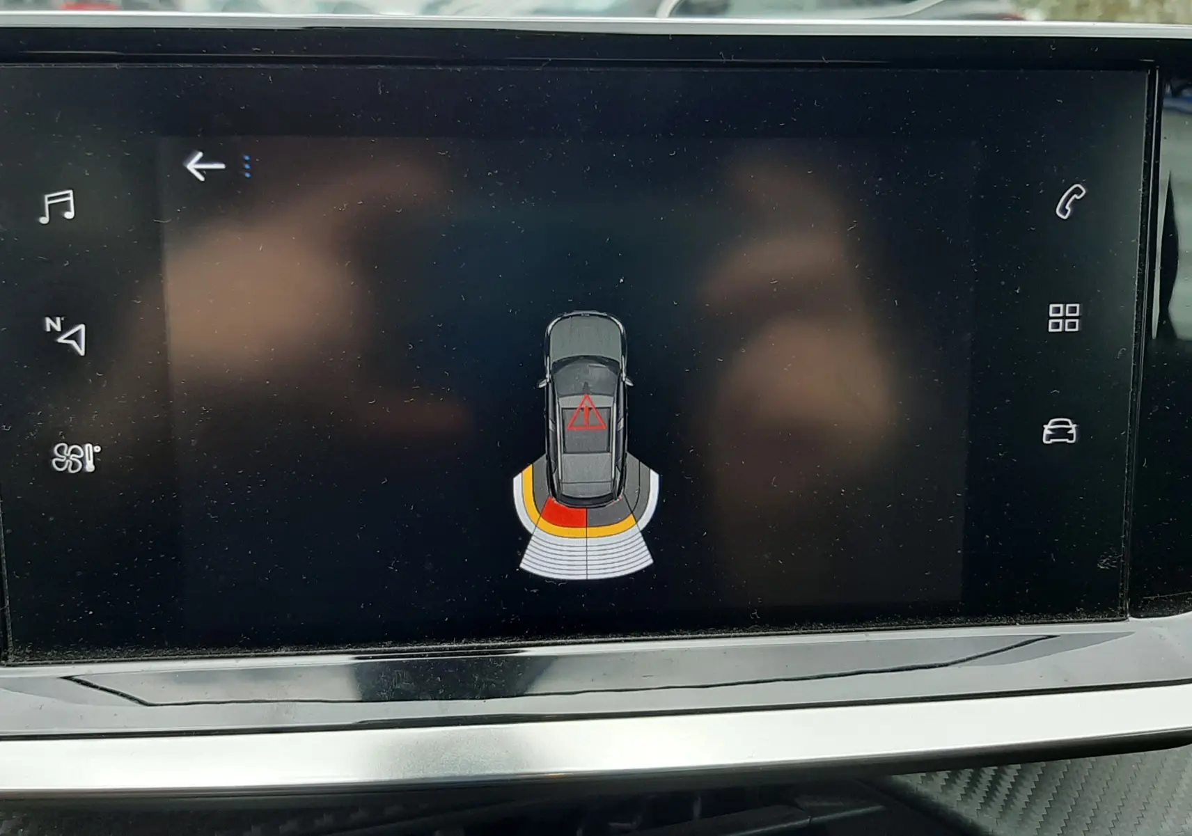 Écran tactile intérieur affichant le système d’aide au stationnement du Peugeot 2008 gris Artense, vue de face du tableau de bord.