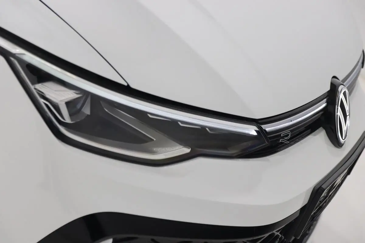 Gros plan sur le phare avant gauche et la calandre blanche d'une Volkswagen Golf 2.0 TDI R-Line 2025.
