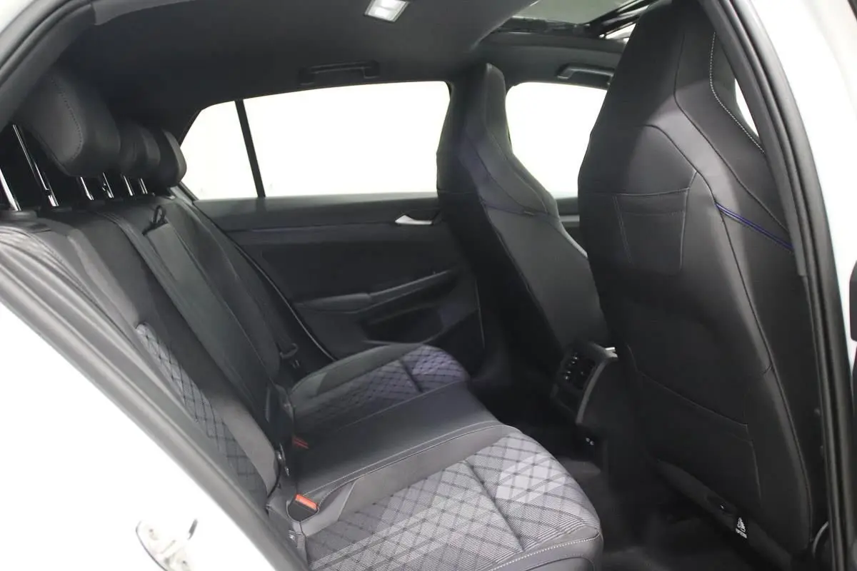 Vue intérieure arrière côté gauche de la Volkswagen Golf 2.0 TDI 150 DSG R-Line blanche, sièges sport en cuir noir avec surpiqûres.