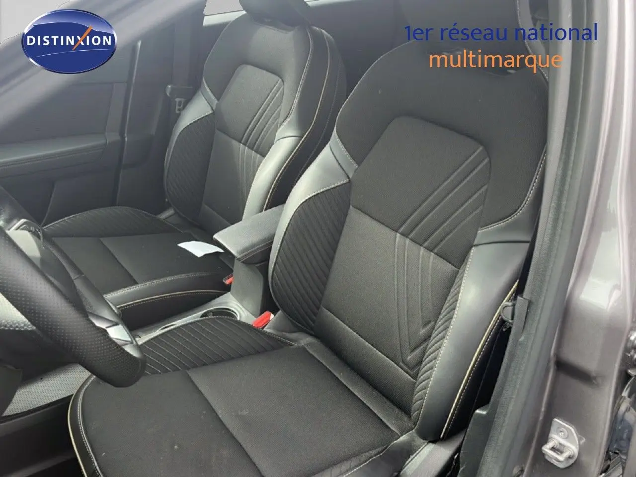 Vue intérieure des sièges avant en tissu noir avec surpiqûres contrastantes du Renault Symbioz gris cassiopée 2025.
