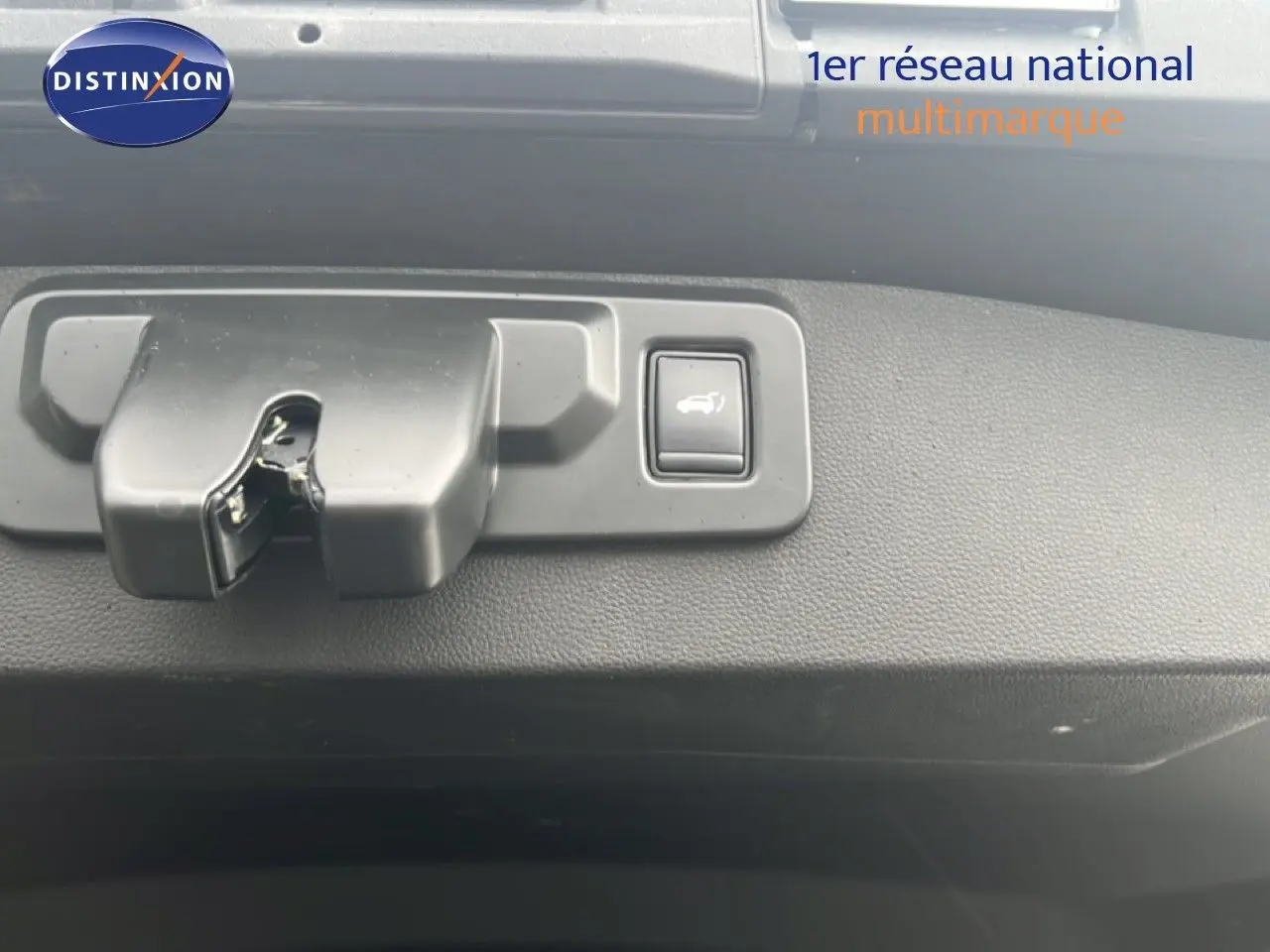 Détail du bouton d'ouverture du hayon sur la porte arrière d'un Renault Symbioz gris cassiopée métal.