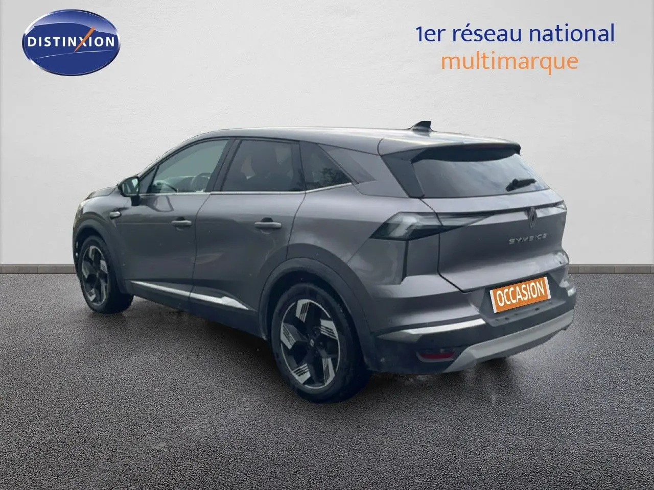 Vue 3/4 arrière droite d’un Renault Symbioz gris cassiopée métallisé avec jantes modernes et feux arrière LED.