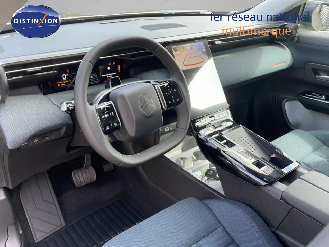 Vue intérieure côté conducteur du Citroën C5 Aircross Hybrid 2026, avec tableau de bord moderne et sellerie tissu bleu.