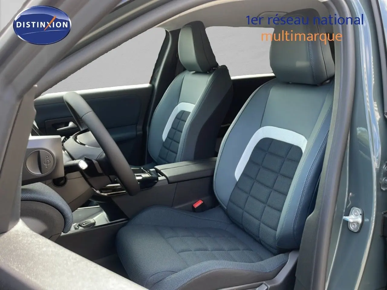 Vue intérieure côté conducteur du Citroën C5 Aircross Hybrid 2026 avec sièges tissu bleu et cuir gris clair.