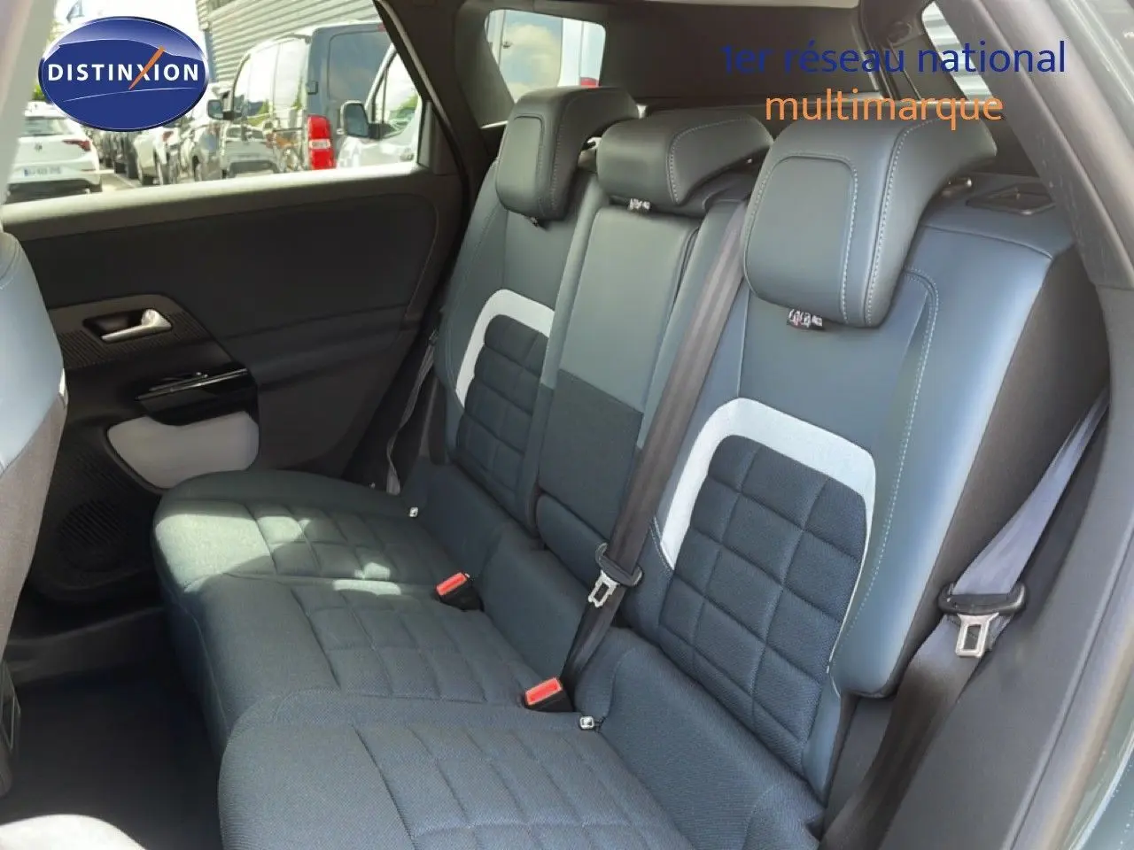 Vue intérieure des sièges arrière du Citroën C5 Aircross Hybrid 2026 avec sellerie tissu et cuir noir et détails gris.