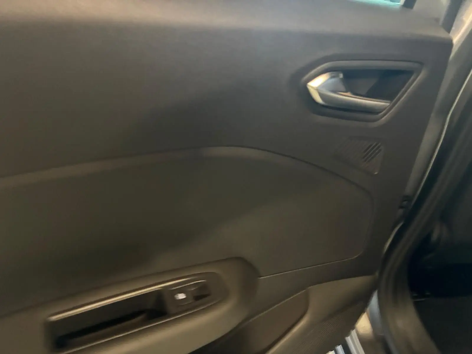 Vue intérieure côté gauche sur la porte arrière d'une Renault Clio gris schiste, avec poignée et commande de fenêtre.