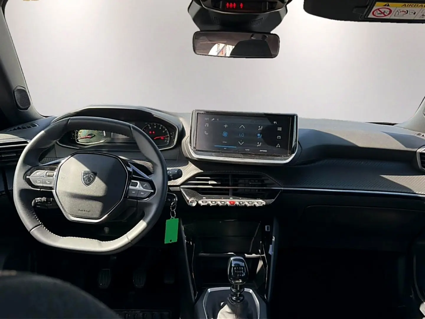 Intérieur de la Peugeot 2008 1.2 100 style 2025, vue frontale du tableau de bord avec écran tactile et volant multifonction.