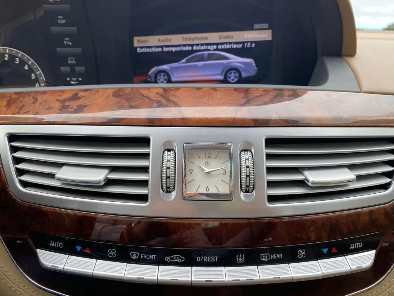 Plan rapproché du tableau de bord en bois Designo de la Mercedes Classe S 600 L, avec horloge analogique et commandes climatisation.