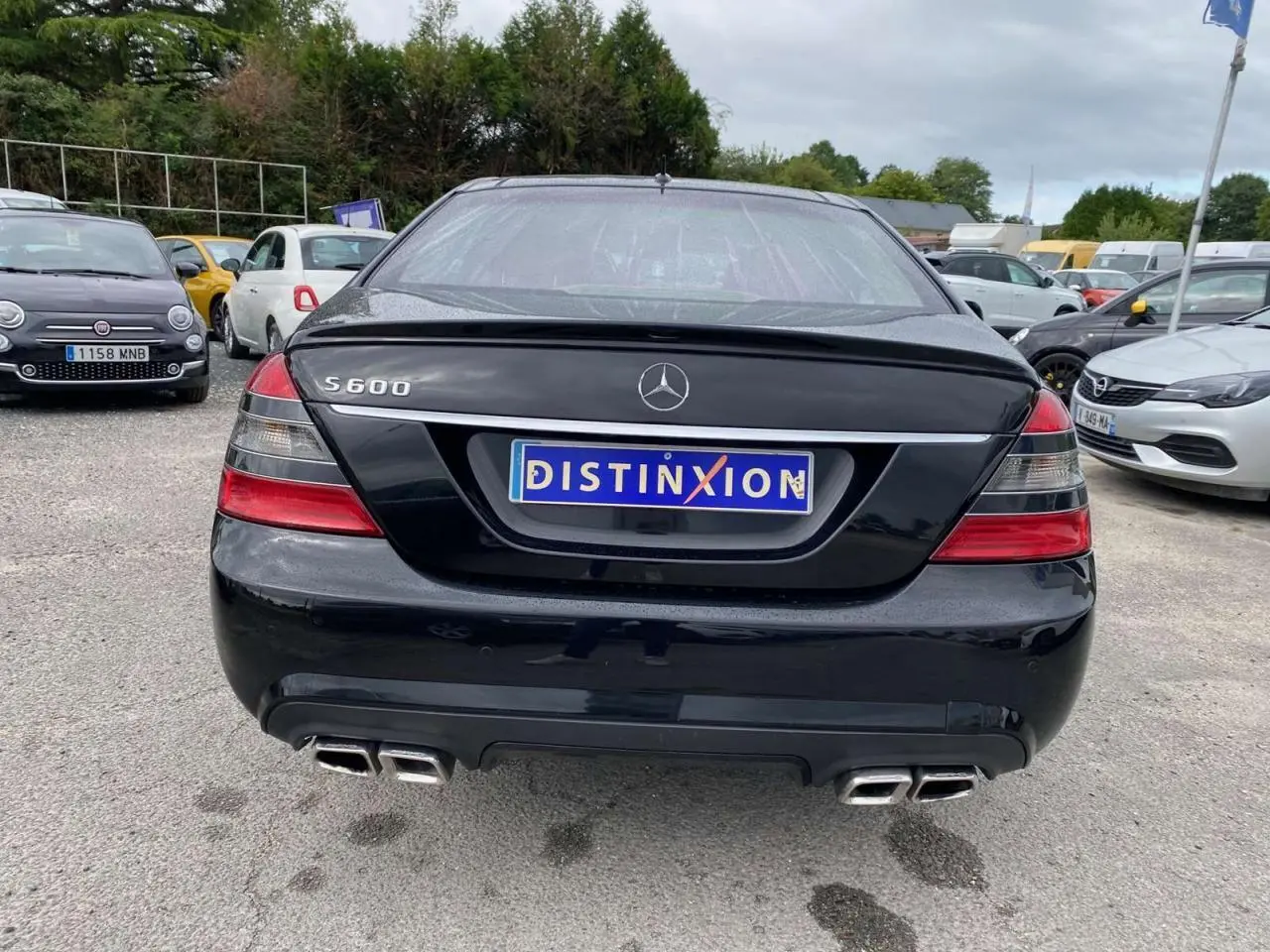 Vue arrière d'une Mercedes Classe S 600 L noire avec double sortie d'échappement AMG et logo S600 visible.