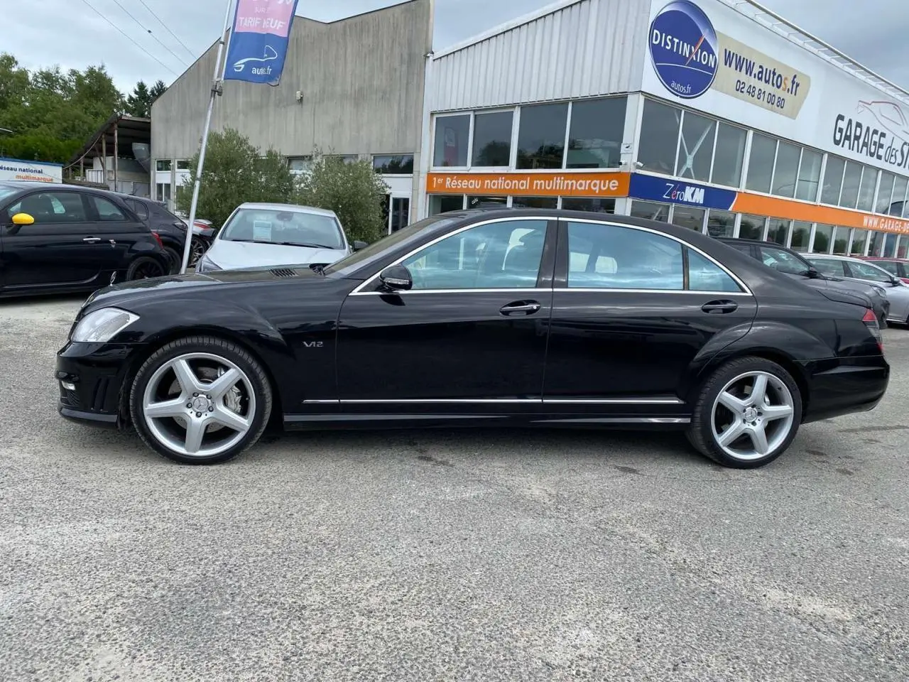 Profil côté gauche d'une Mercedes Classe S 600 L noire avec jantes AMG 20 pouces et badge V12 visible.