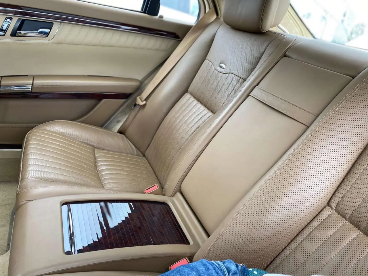 Vue rapprochée de la banquette arrière en cuir beige de la Mercedes Classe S 600 L avec inserts bois Designo.