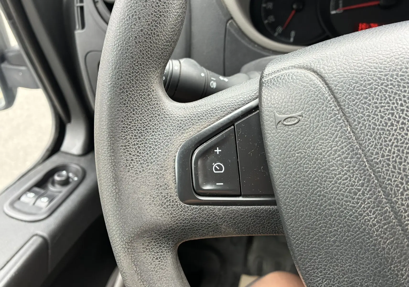 Gros plan sur le volant noir de l'Opel Movano Fourgon 2017, avec commandes de régulateur de vitesse visibles côté gauche.