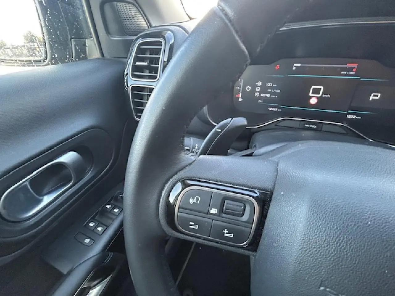 Vue rapprochée du volant et tableau de bord numérique du Citroën C5 Aircross 2022 en intérieur noir.