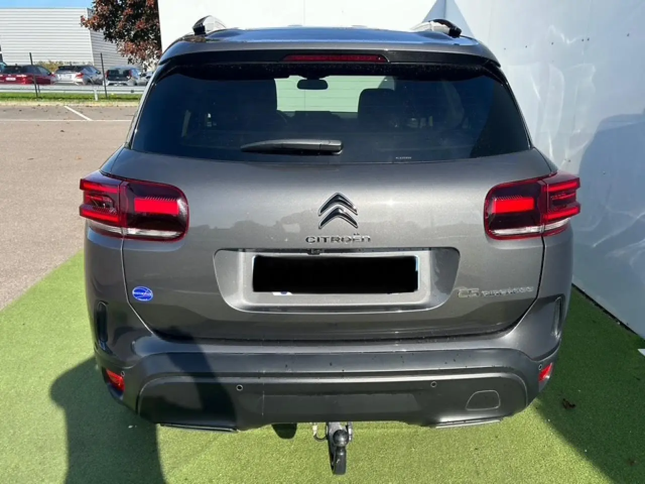 Vue arrière d'un Citroën C5 Aircross gris platinium avec attelage et feux arrière LED visibles.